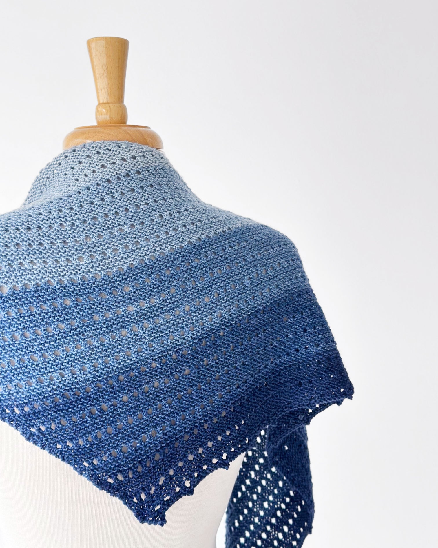 Back of the Woolsia Shawl knit in a blue gradient yarn.