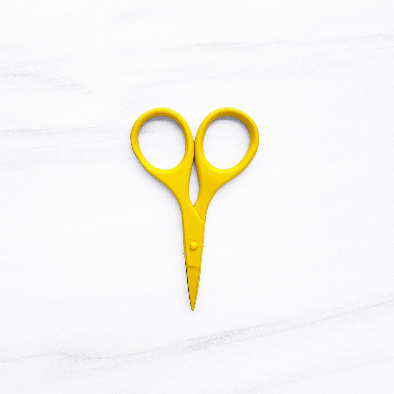 Yellow scissors on white background