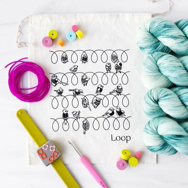 Birds on wire design with yarn and craft supplies.