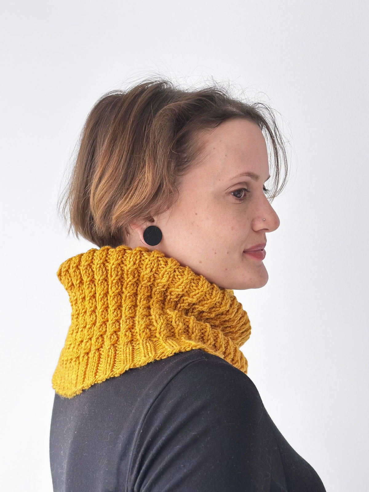 Baby cable knit cowl in gold worn by woman