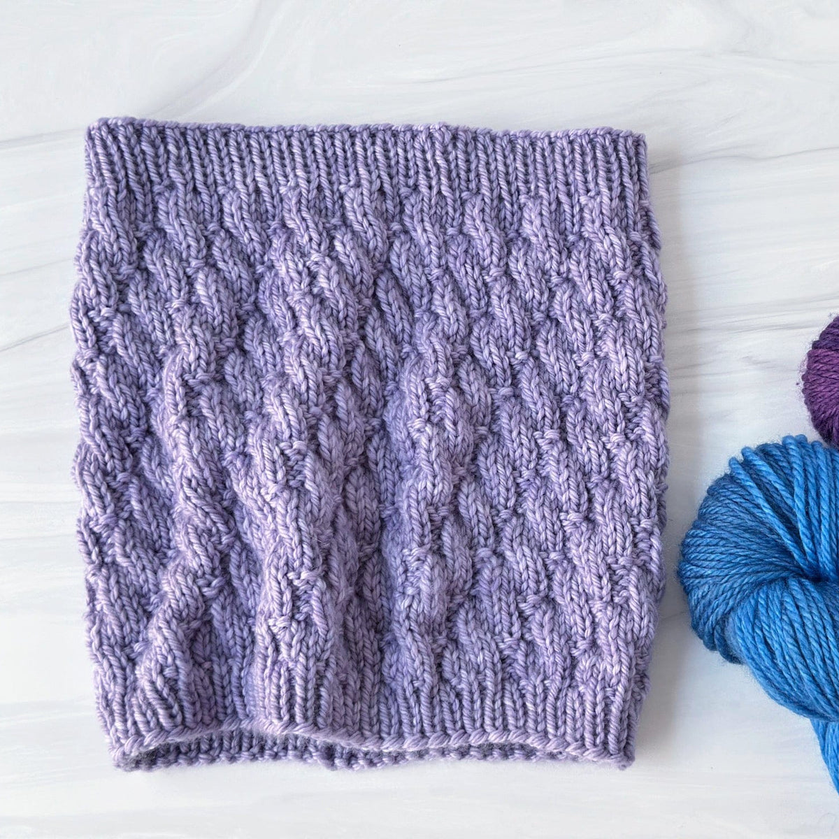 Trellis Cowl in lavender with colorful yarn balls