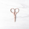 Blush pink scissors on white marble background