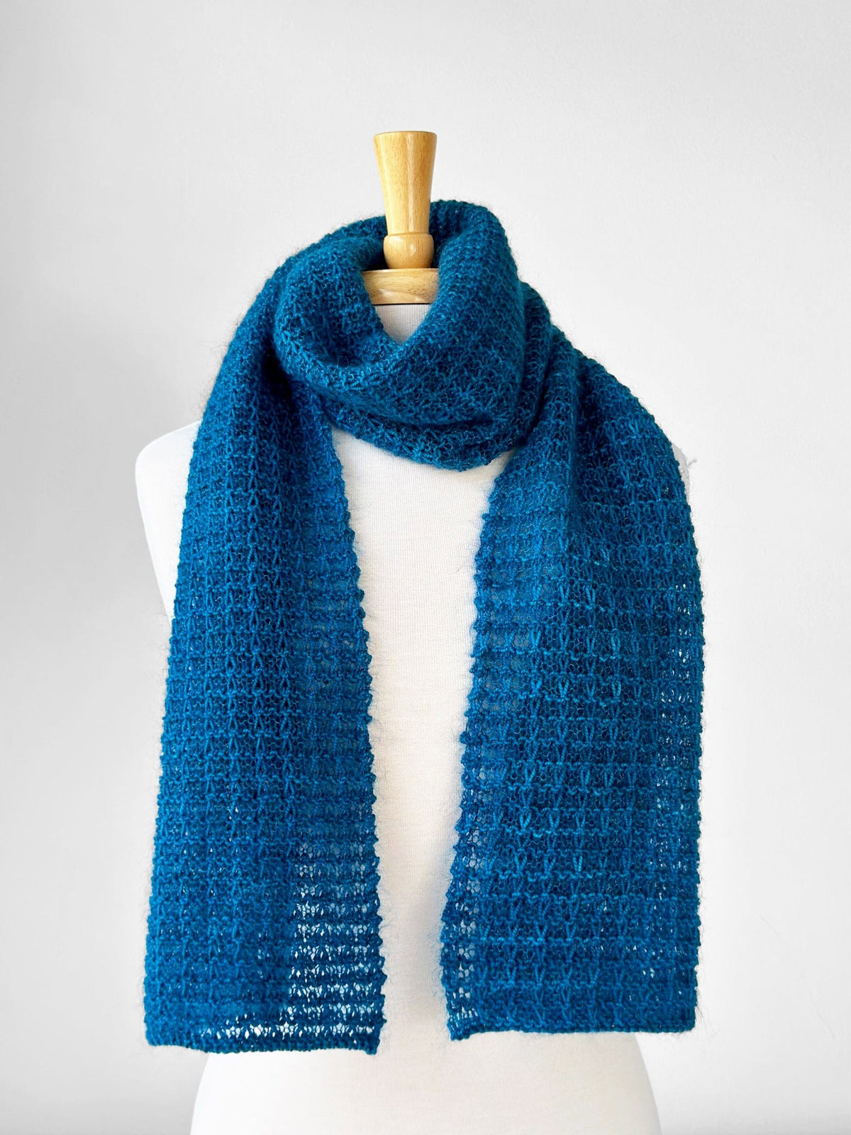 Blue knitted scarf on mannequin