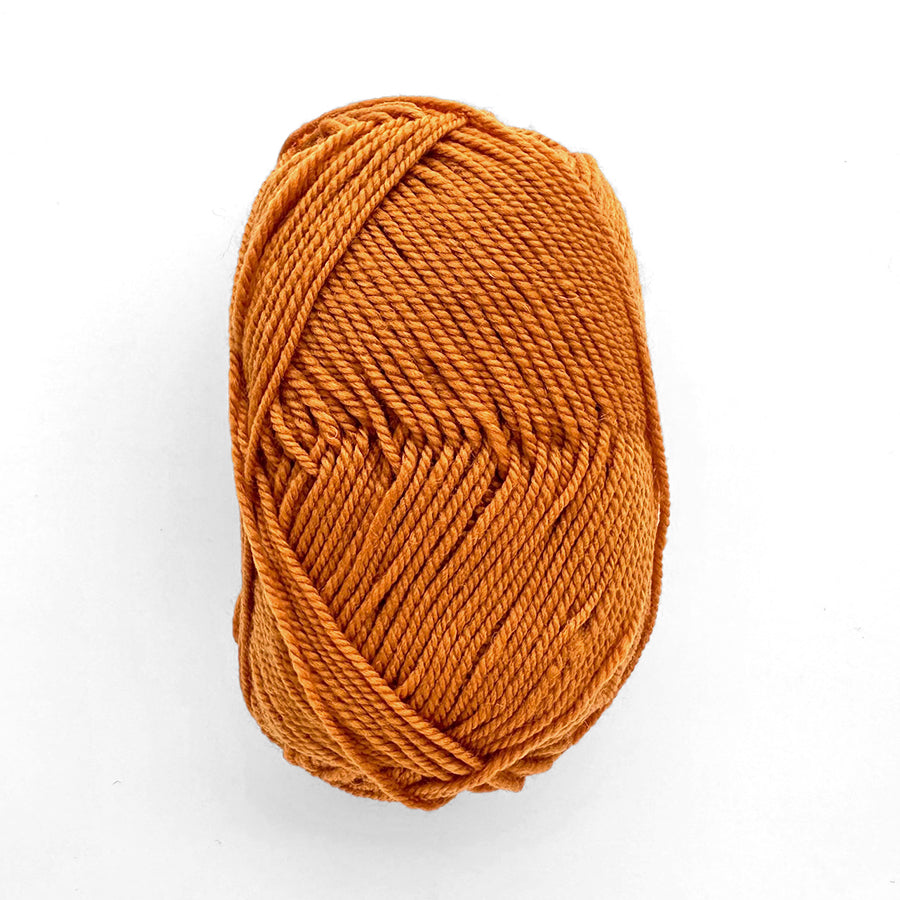 Ball of orange yarn on a white background