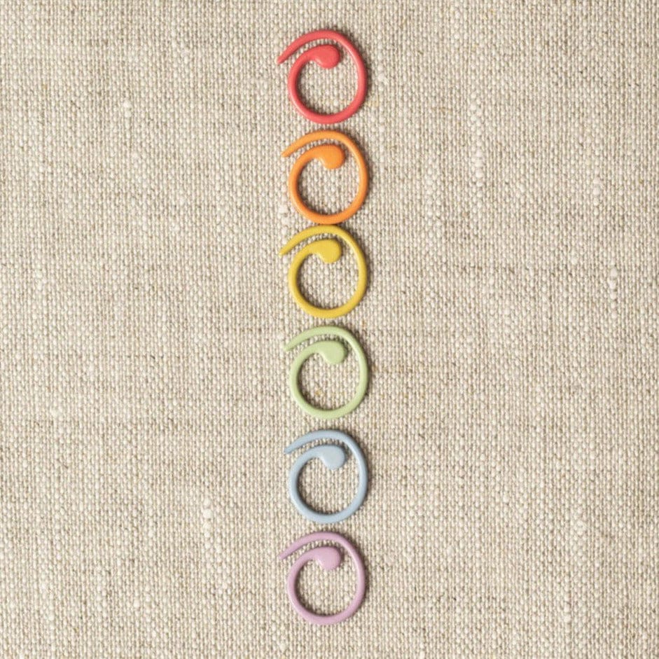 Colorful stitch markers on linen