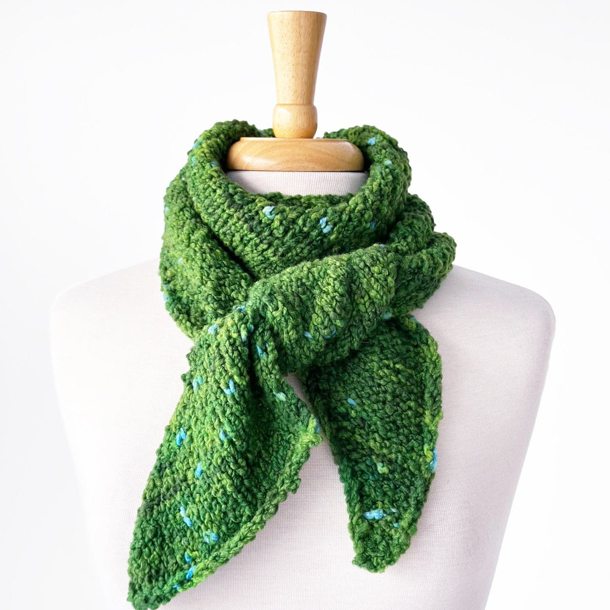 Green knit fiber bias scarf on mannequin