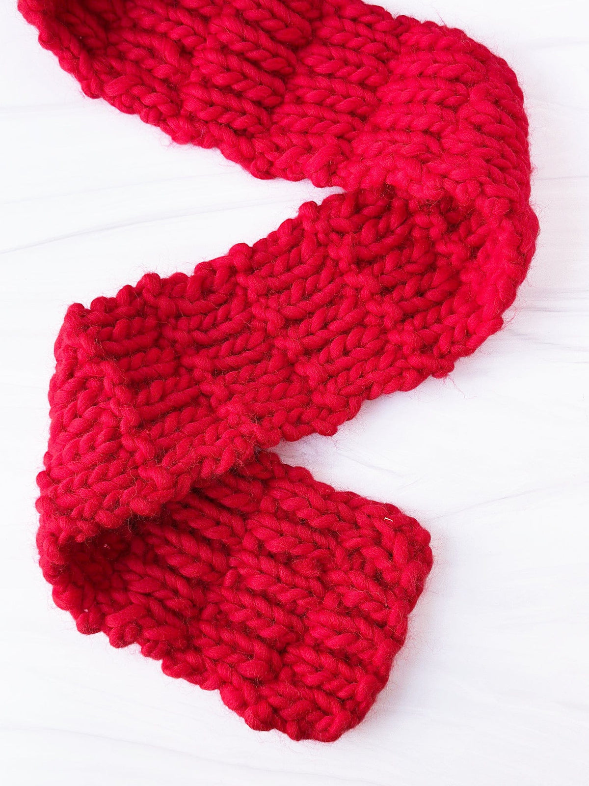 Red knitted scarf flat lay